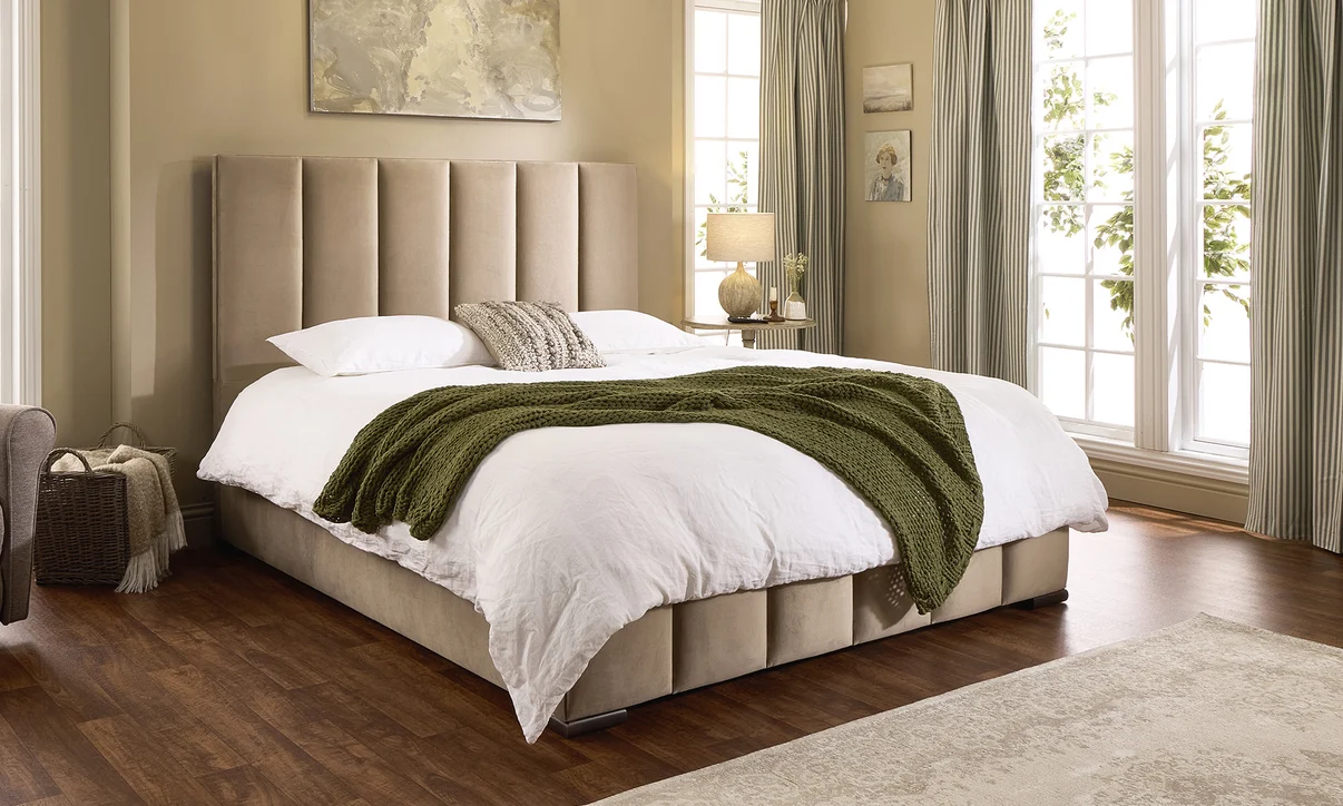 The Mayfair adjustable bed dressed with white bedding and a green throw in a light-filled bedroom