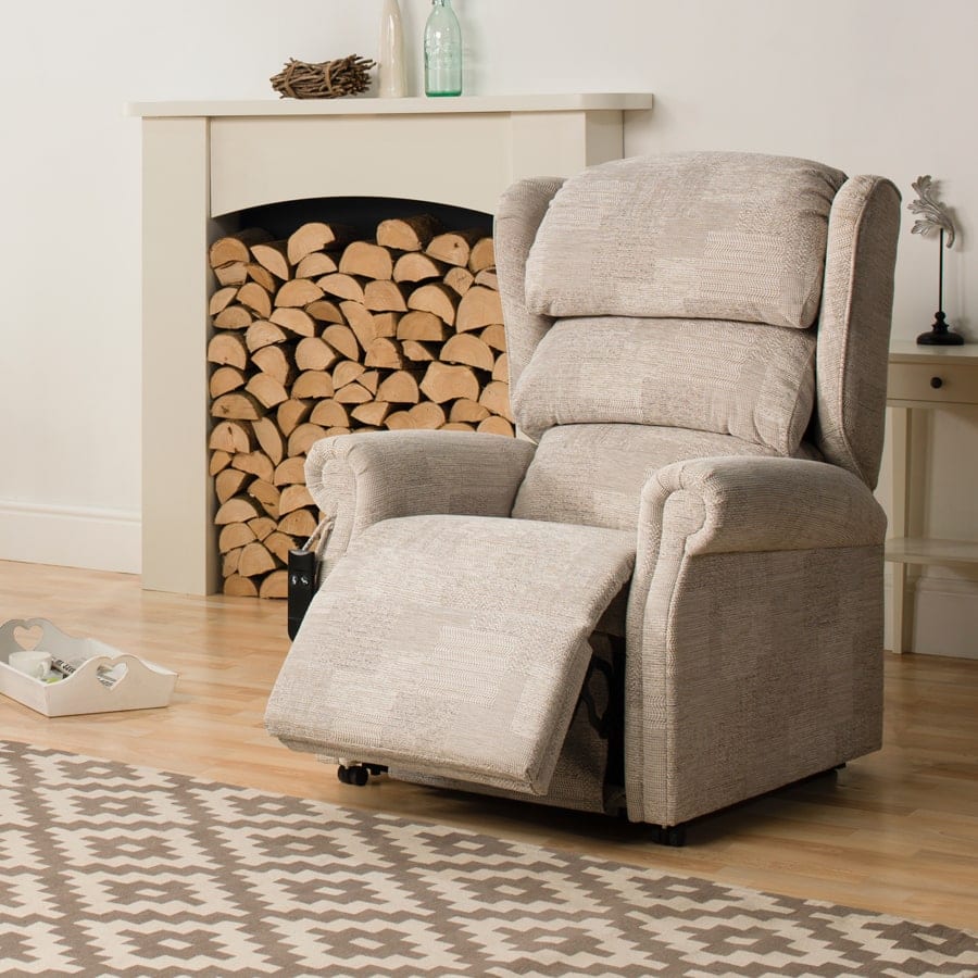 The Chatsworth waterfall riser recliner with its footrest extended beside a fireplace